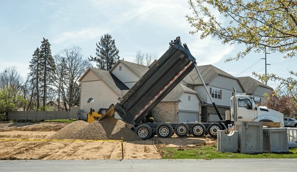 Dump truck dropping material at job site